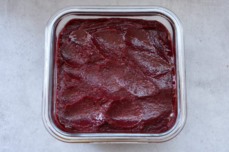 Concord grape sorbet in a glass container for freezing.