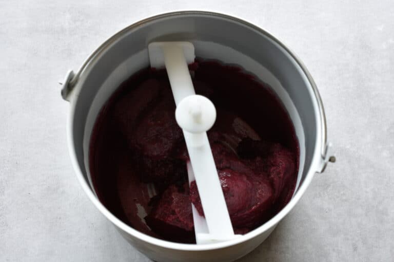 Concord grape sorbet in the basket of an ice cream maker.