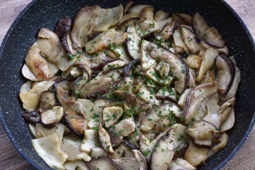 Funghi porcini trifolati - Sautéed porcini mushrooms in a pan.