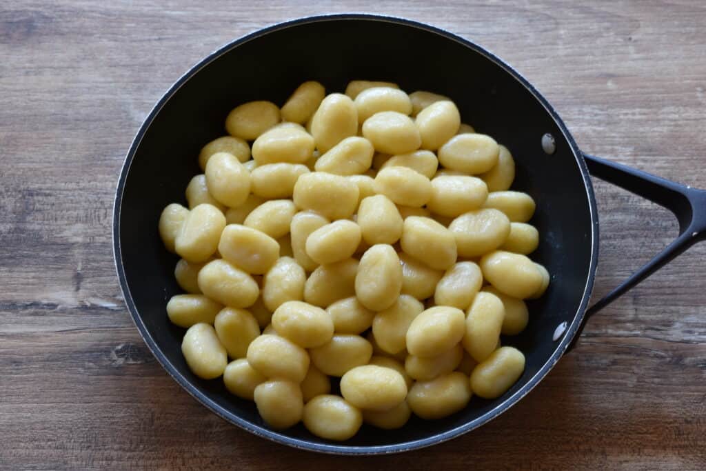 Cooked potato gnocchi in a pan on a table.