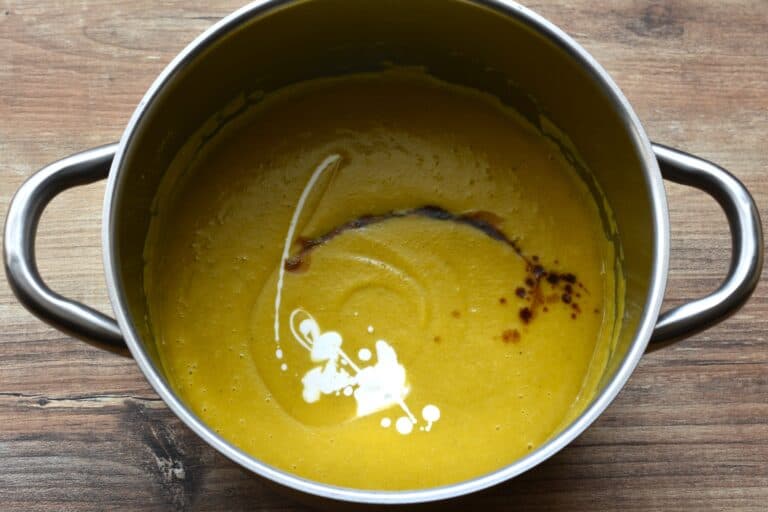 Pumpkin and red lentil soup in a pan with the addition of soy sauce and coconut milk,