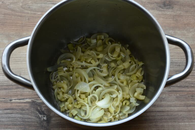 Sautéed onion and celery in a pan.