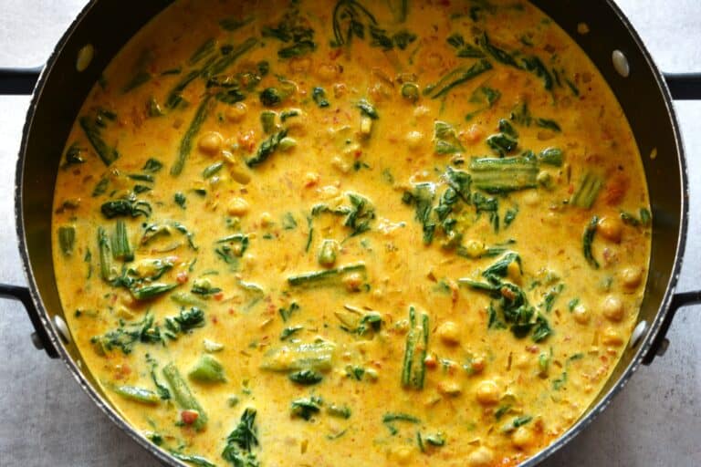 A close-up image of quick vegan chickpea and spinach curry in a saucepan