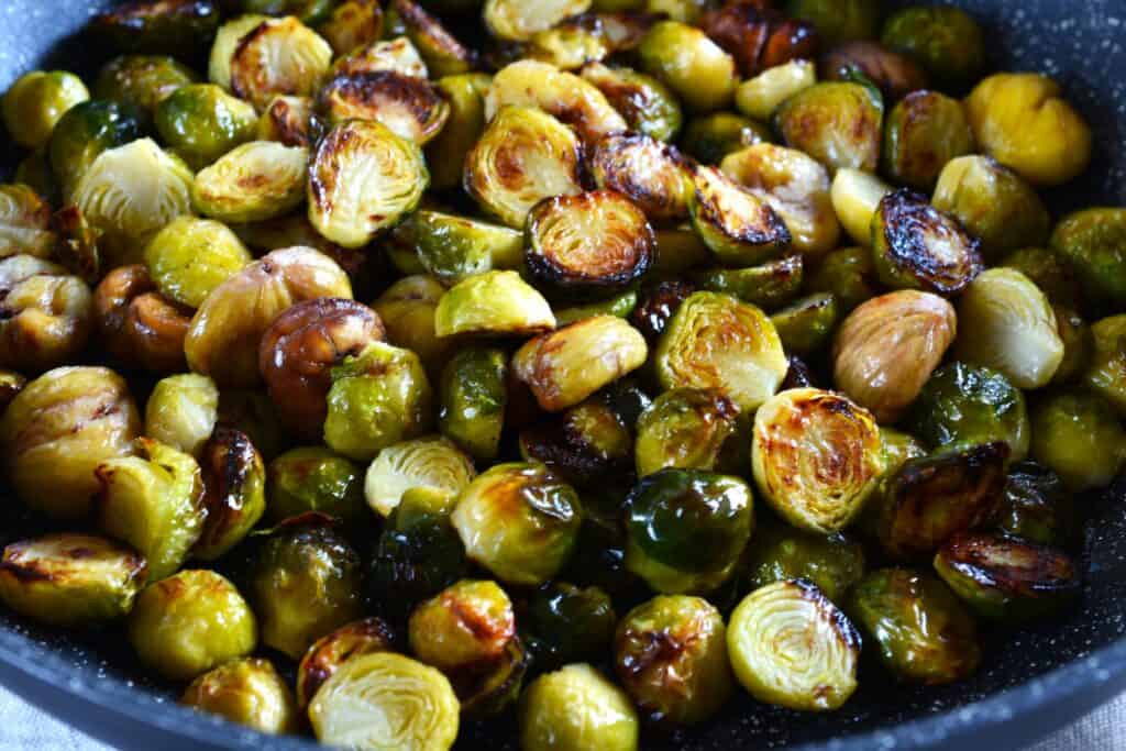 A close-up image of roasted Brussels sprouts with chestnuts.