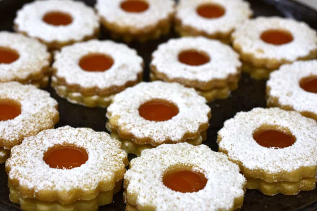 A close-up image of vegan Spitzbuben biscuits with apricot jam filling.