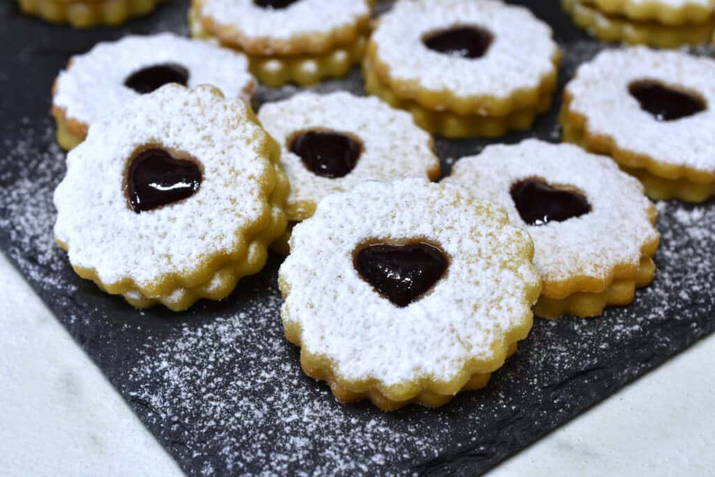 A close-up image of vegan Spitzbuben on a grey slate.