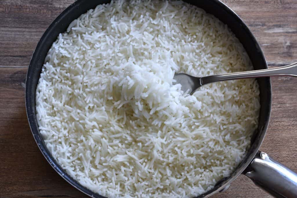 Fluffy white basmati rice in a pan with a fork.