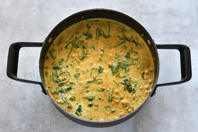 Quick creamy vegan chickpea and spinach curry in a saucepan.