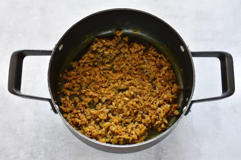 Sautéed onion and Indian spices in a saucepan.