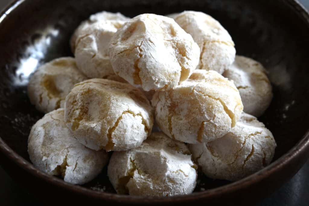 Vegan Italian almond cookies (pizzicotti alle mandorle) in a brown bowl.