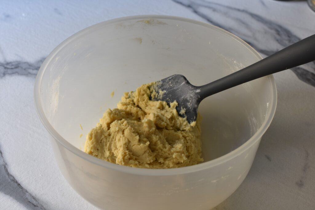 Vegan Spitzbuben biscuit paste in a bowl with a spatula.