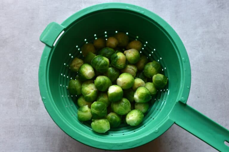 Blanched Brussels sprouts in a colander.