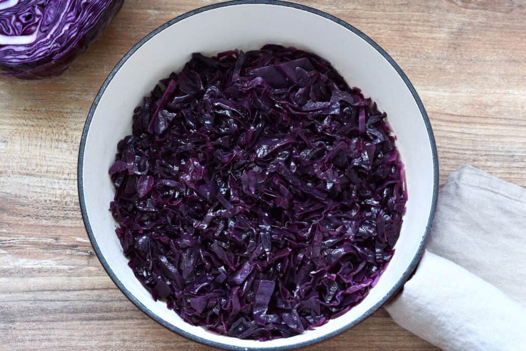 Vegan braised red cabbage Italian style with balsamic vinegar in a pan on a table.