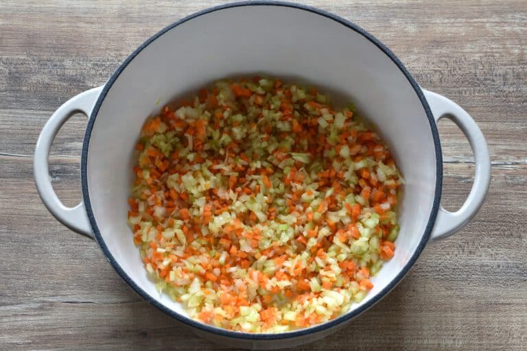 Finely chopped onion, carrot, and celery in a pan with olive oil.