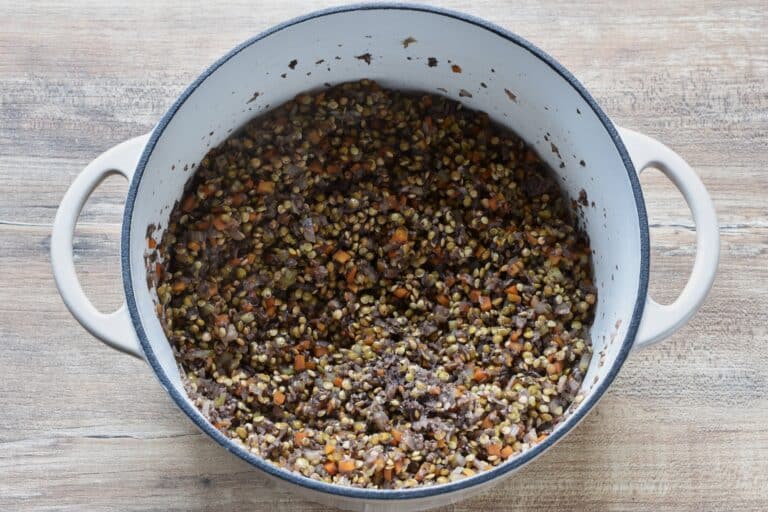 Soffritto, finely chopped mushrooms, lentils, and evaporated red wine in a cast iron pan.