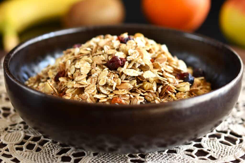 A close-up image of raw vegan granola in a brown bowl.