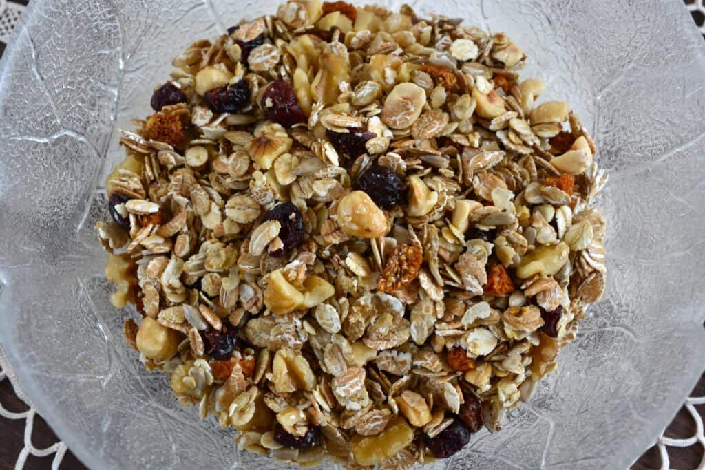 A close-up image of raw vegan granola in a glass bowl.