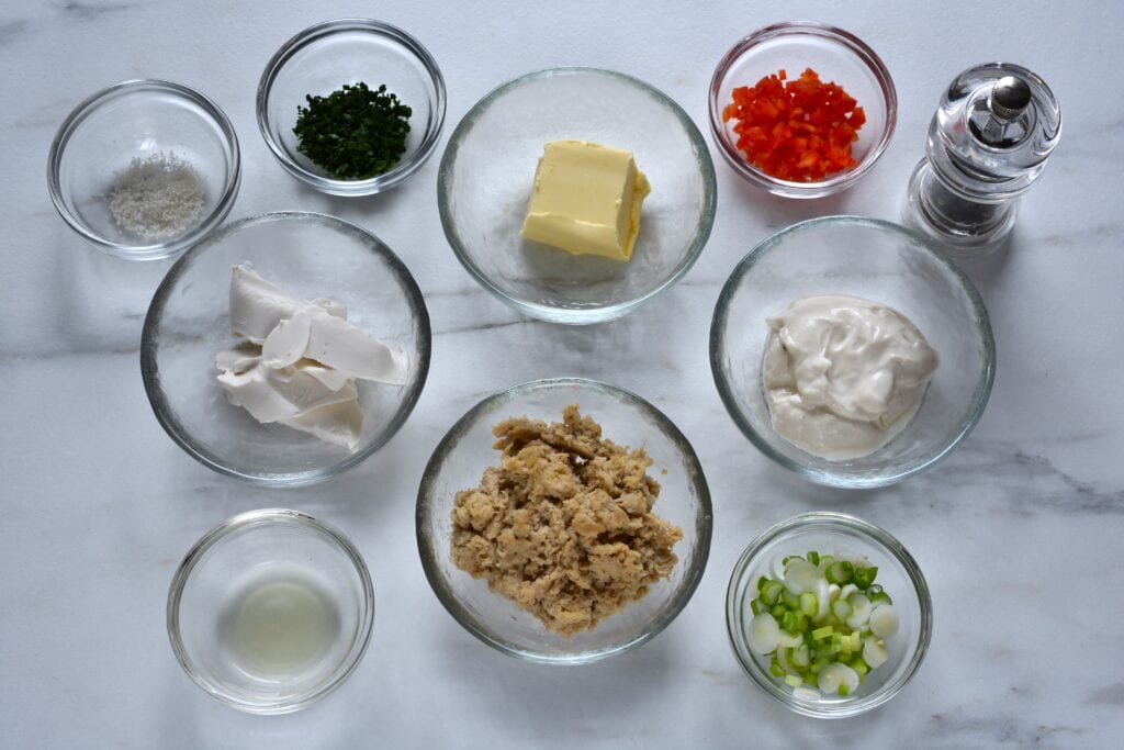 Ingredients for vegan tuna paté in individual glass bowls on a kitchen worktop.