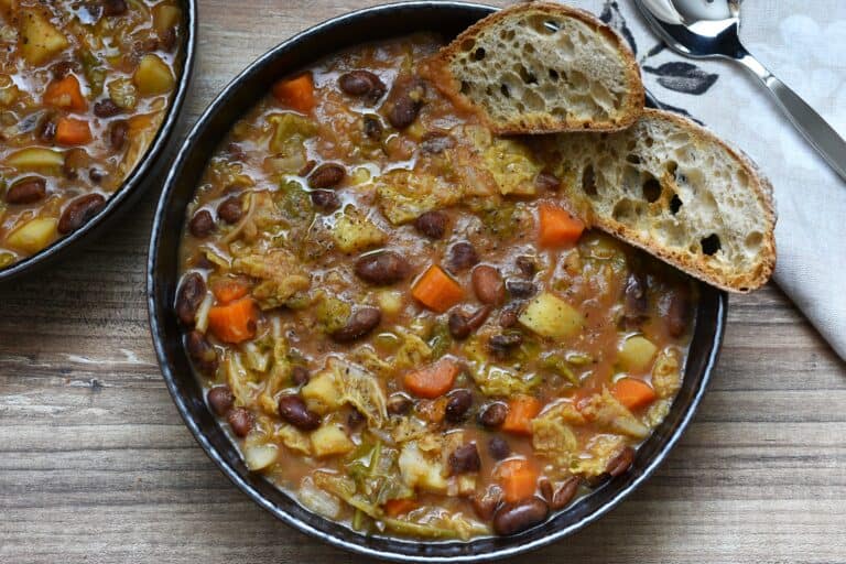 Italian stregoni bean soup with two slices of bruschetta in a brown bowl.