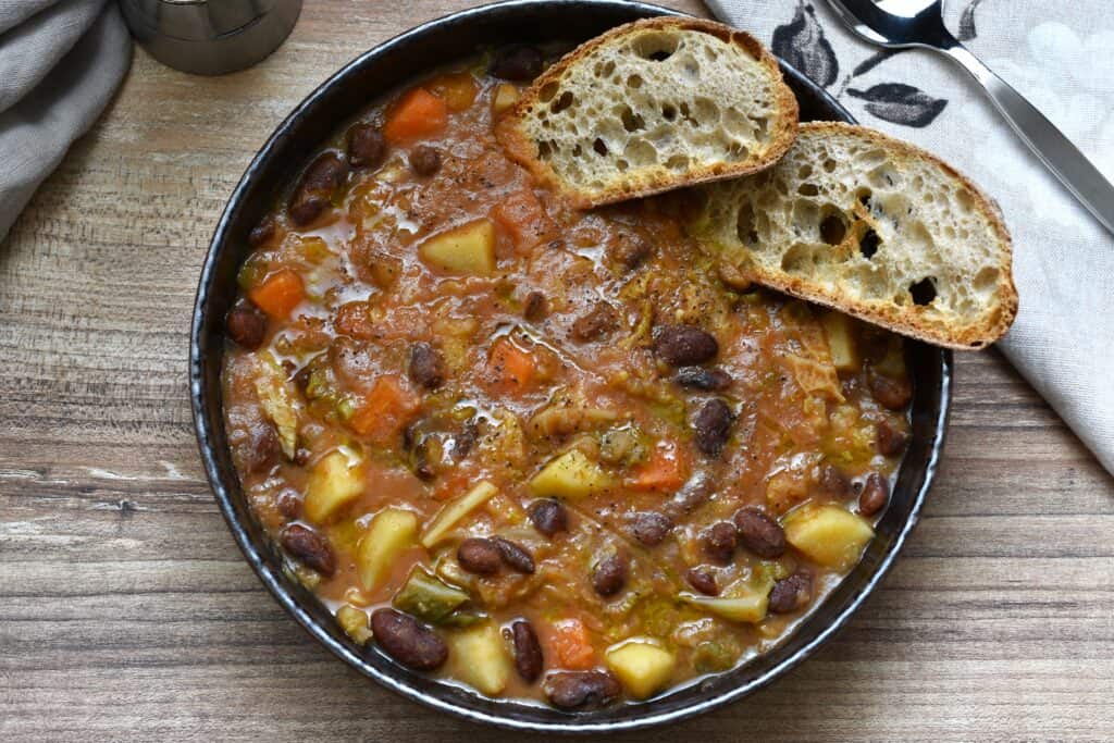 Stregoni beans soup with bruschetta in a brown bowl.