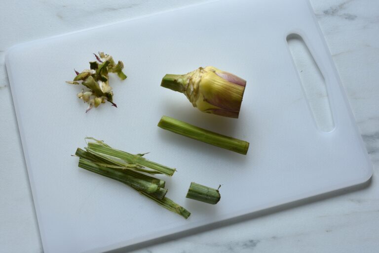 Pieces of an artichoke on a chopping board.