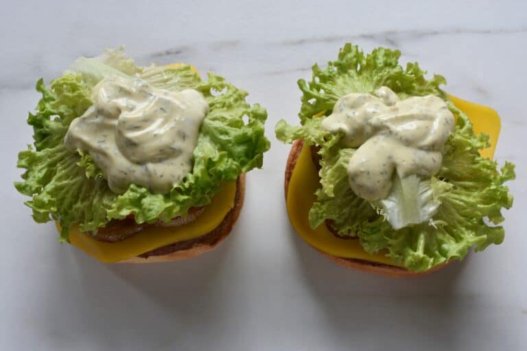 Vegan burger bun bases topped with cheeseburger ingredients.