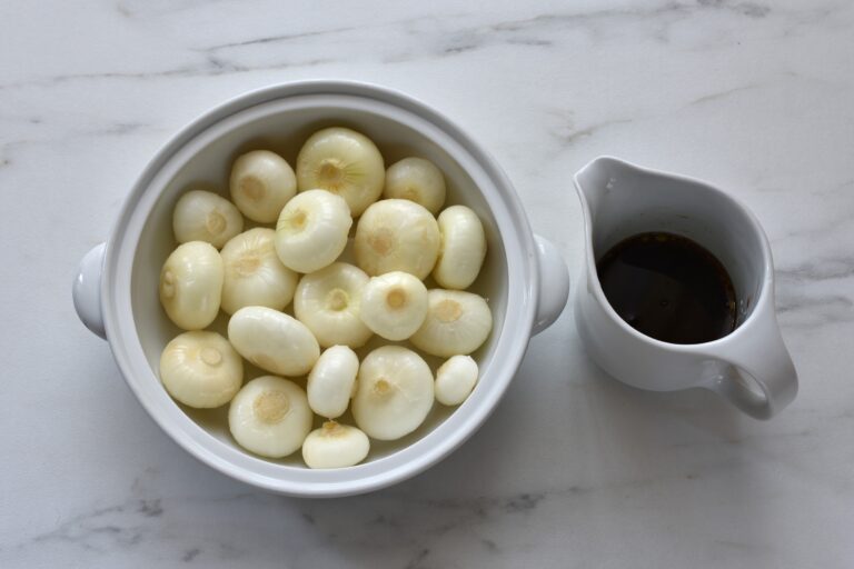 Borettane onions in an oven dish and olive oil balsamic vinegar mix in a jug.