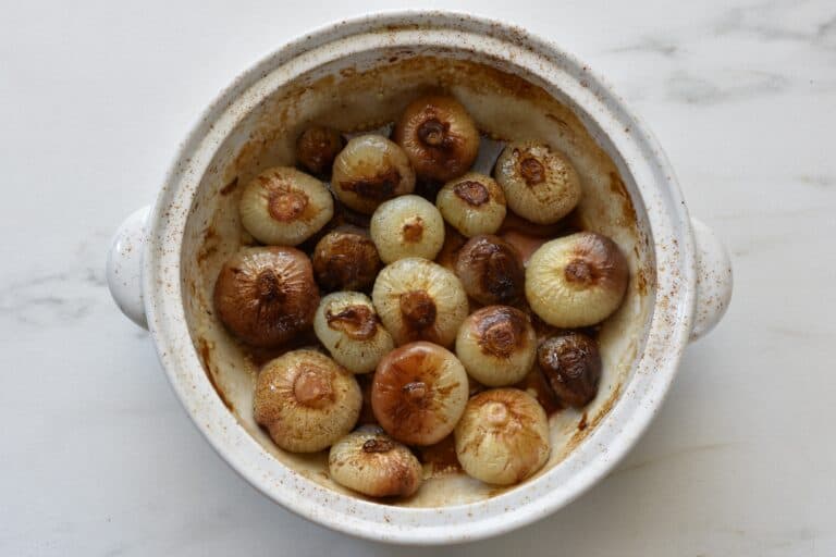 Roasted borettane onions in balsamic vinegar in an oven dish.