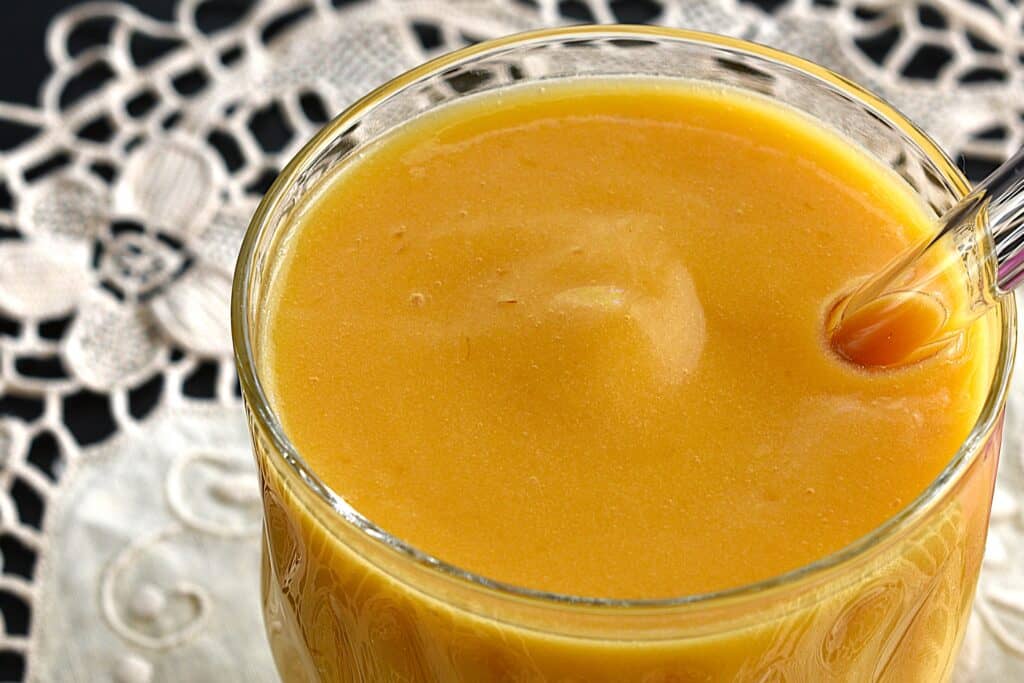 A close-up image of a mango and pineapple protein smoothie.