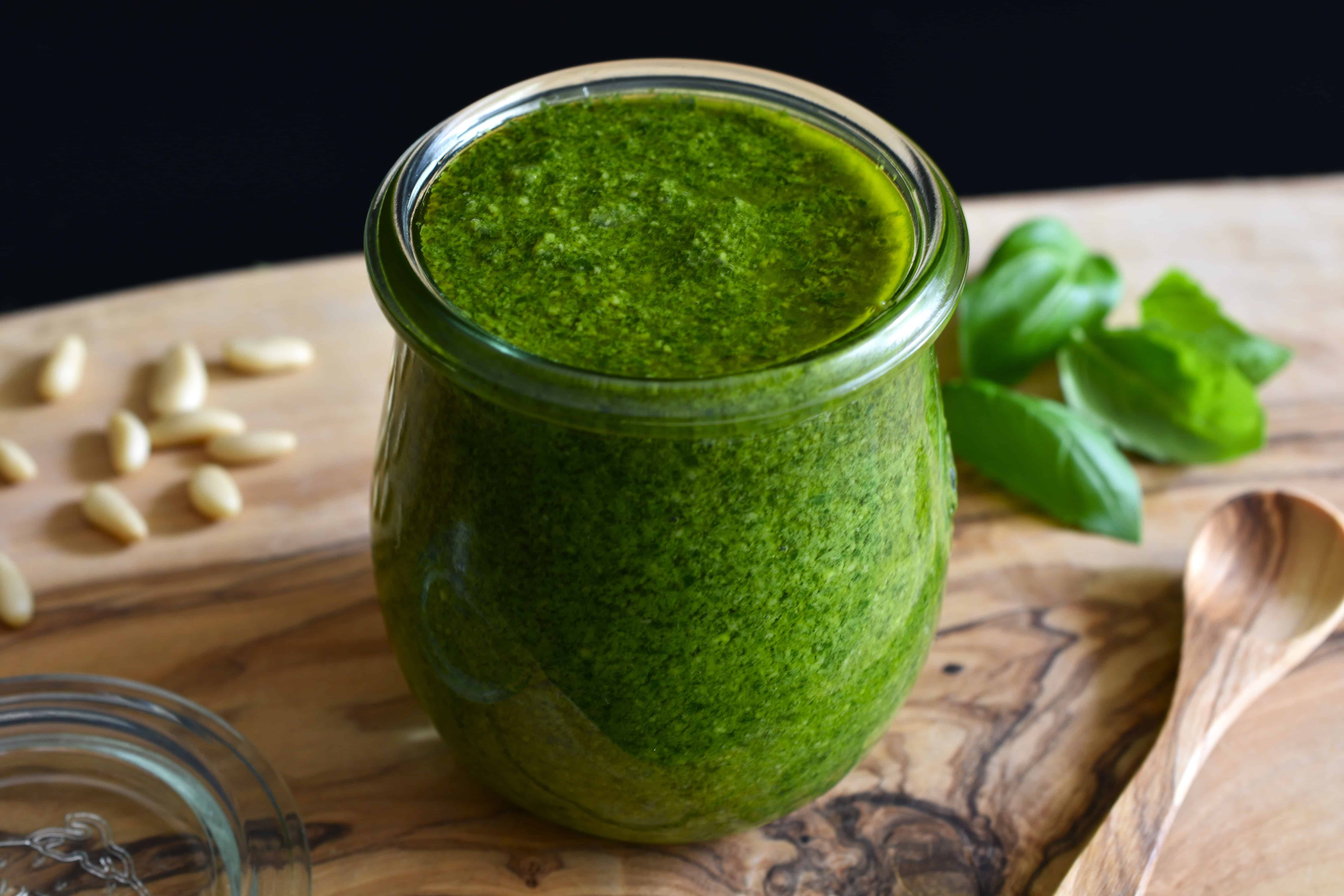 Homemade vegan basil pesto alla genovese in a glass jar.