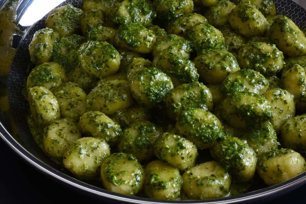 A close-up image of a pan of homemade vegan pesto gnocchi