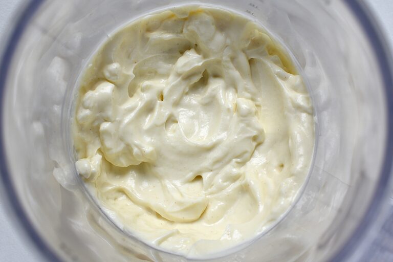 A close-up image of vegan mayonnaise in a blender beaker.