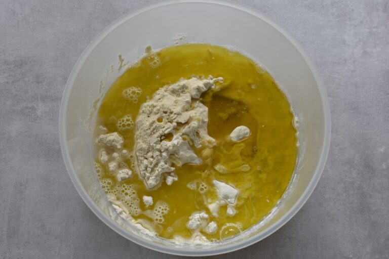 Flour, water, olive oil and salt (ingredients for pasta matta) in a bowl.