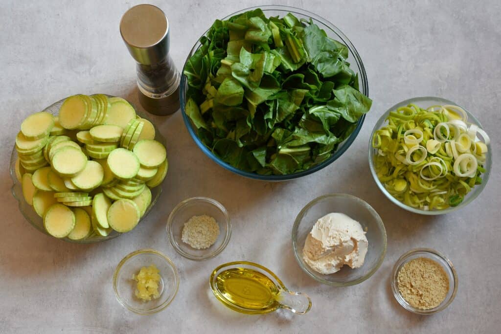 Ingredients for Ligurian torta verde in individual glass bowls on a work top.