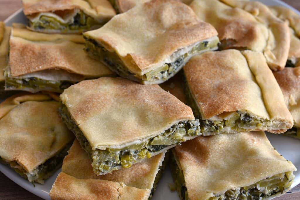 Pieces of torta verde di Sanremo (Italian green vegetable pie) on a serving platter.