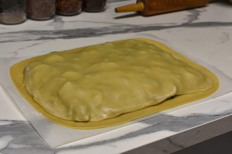 Wet the edges of the top sheet of pastry.