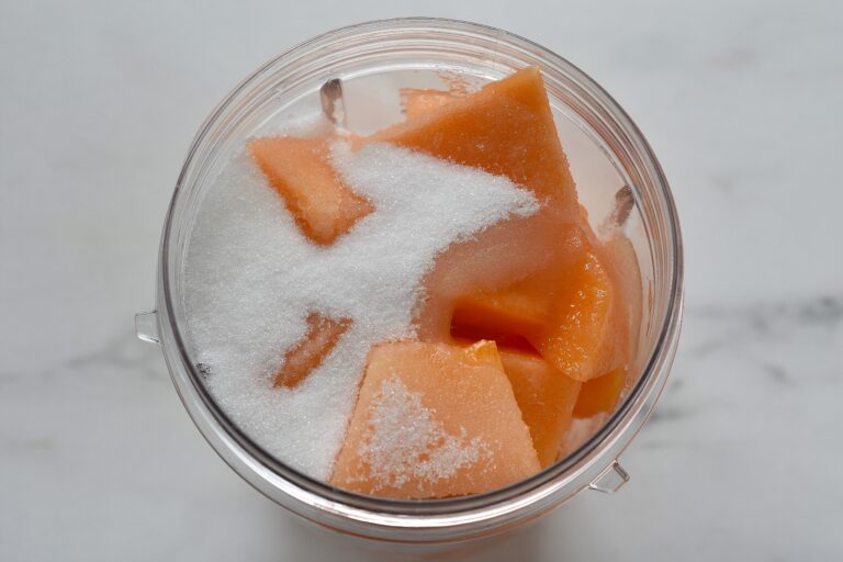 Italian melon, sugar, and lemon juice in a blender beaker.