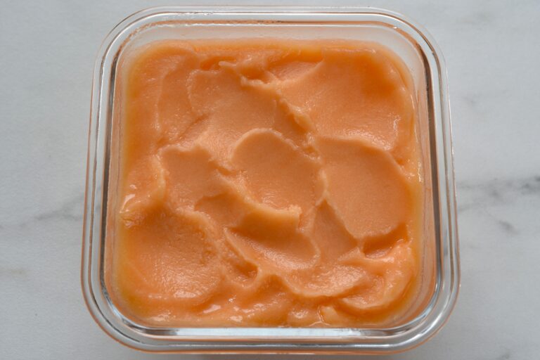 Melon sorbet in a freezer container.