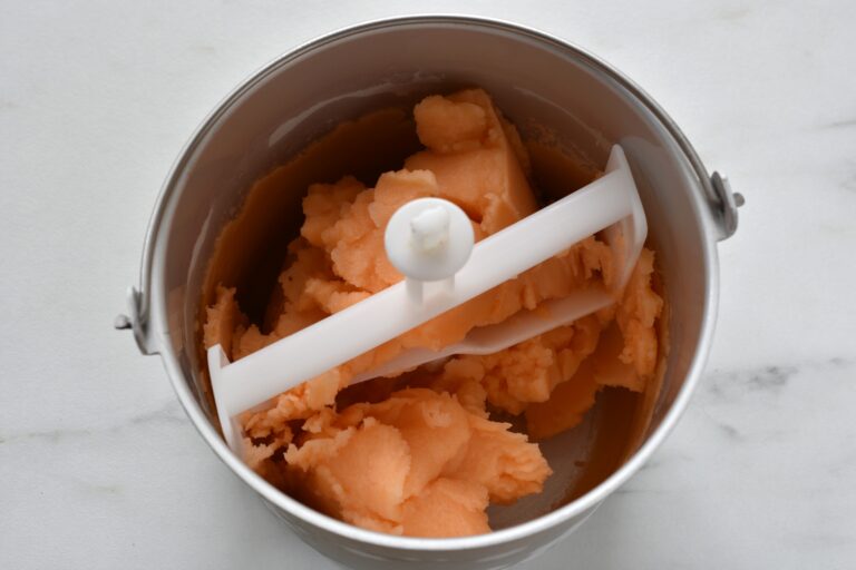 Melon sorbet in the basket of an ice cream maker.