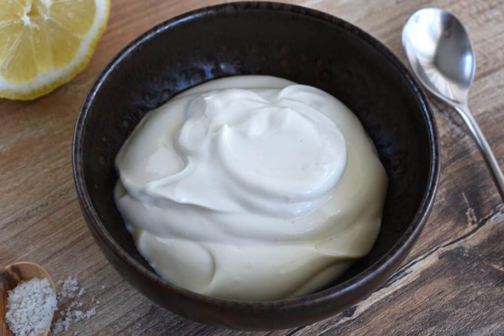 Plain vegan yoghurt sauce in a brown bowl.