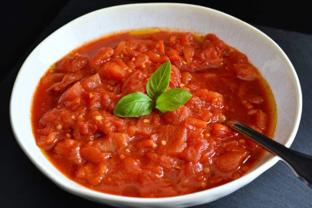 Rustic fresh tomato spaghetti sauce in a bowl with a spoon.