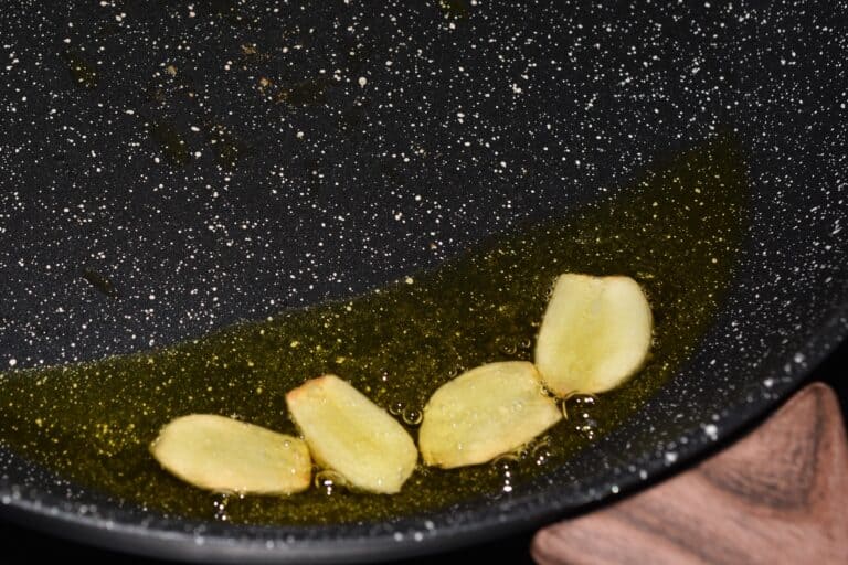 Sautéed garlic in a pan with extra virgin olive oil.