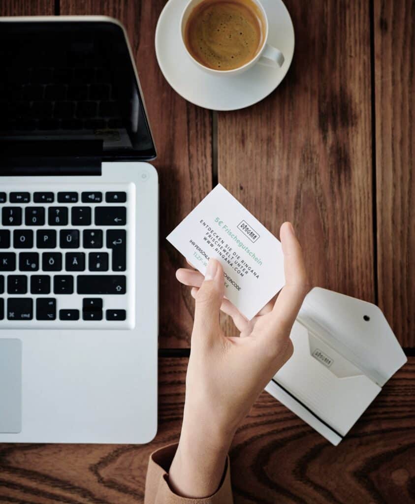 A photo of a laptop, a cup of coffee and a Ringana partner business card.