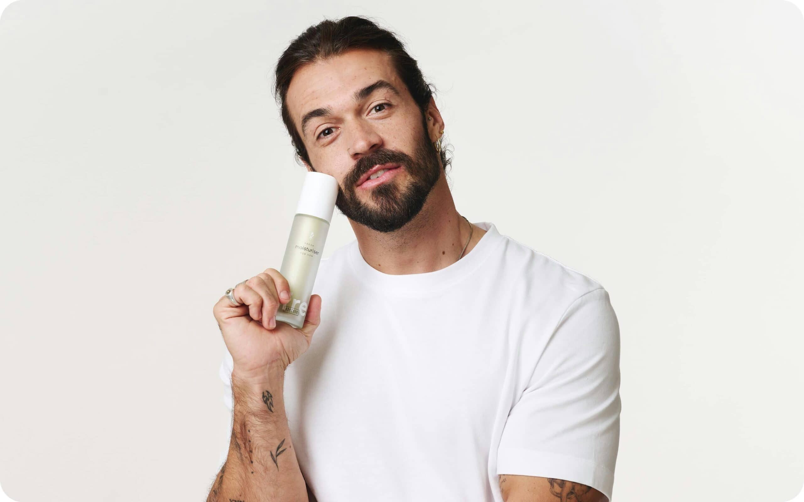 A photo of a man holding a bottle of Ringana moisturiser for men.