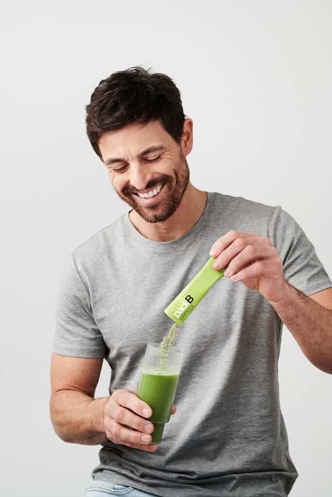 A man with a glass of Ringana fresh vegan pack balancing.