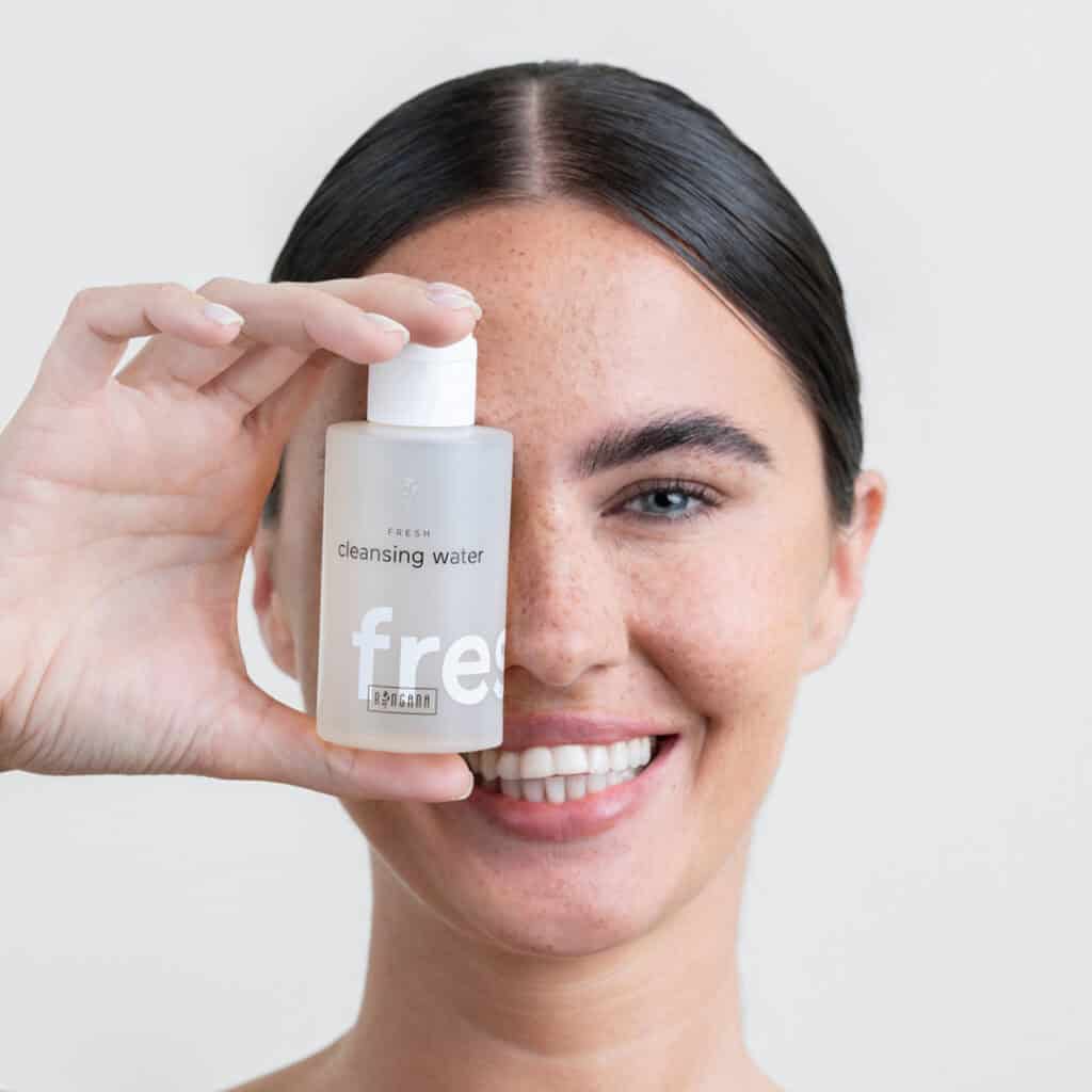 A model holding a bottle of Ringana cleansing water.