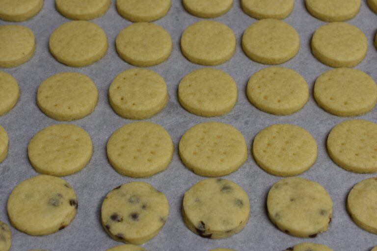 Vegan shortbread biscuits in a baking tray lined with parchment paper.